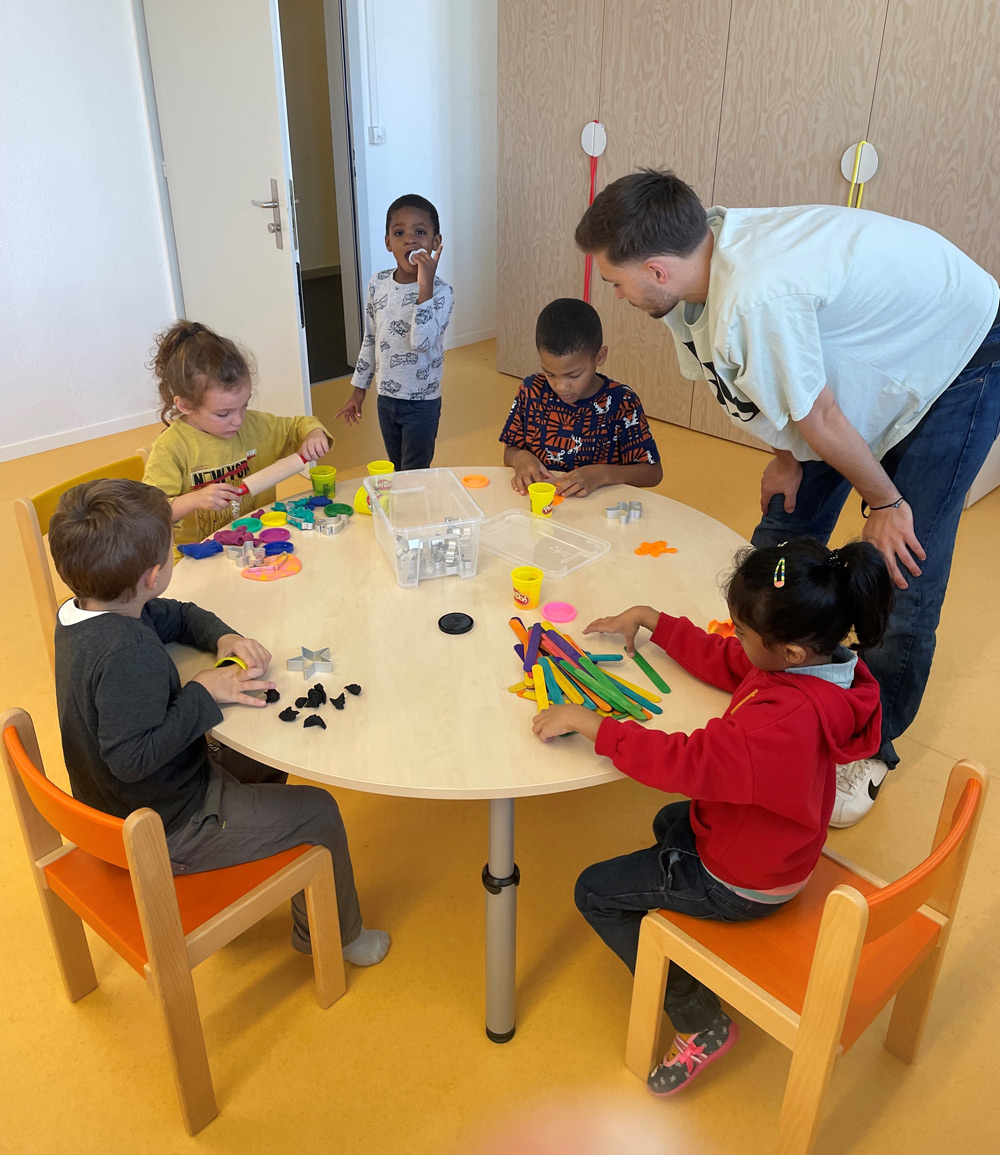 Kids sitting around a table and playing together